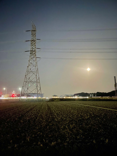 夜間モードで撮影した送電線の鉄塔と月