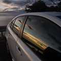 写真: 車のガラスに映る夕焼け