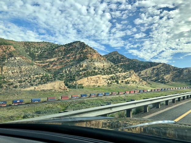 写真: 地層の見える岩山と貨物列車