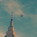 写真: ドコモタワーの横を飛ぶ飛行機