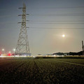 夜間モードで撮影した送電線の鉄塔と月