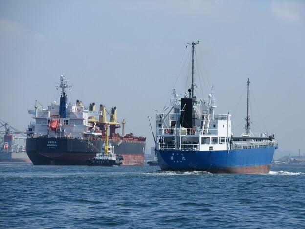 写真: 港口を進む大型船と内航船