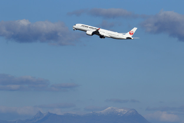 写真: JAL A350とうっすら雪をまとう夕張岳