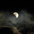 雲の間から食が始まった月が顔を出す