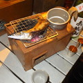 写真: 燗銅壺でサンマを焼く